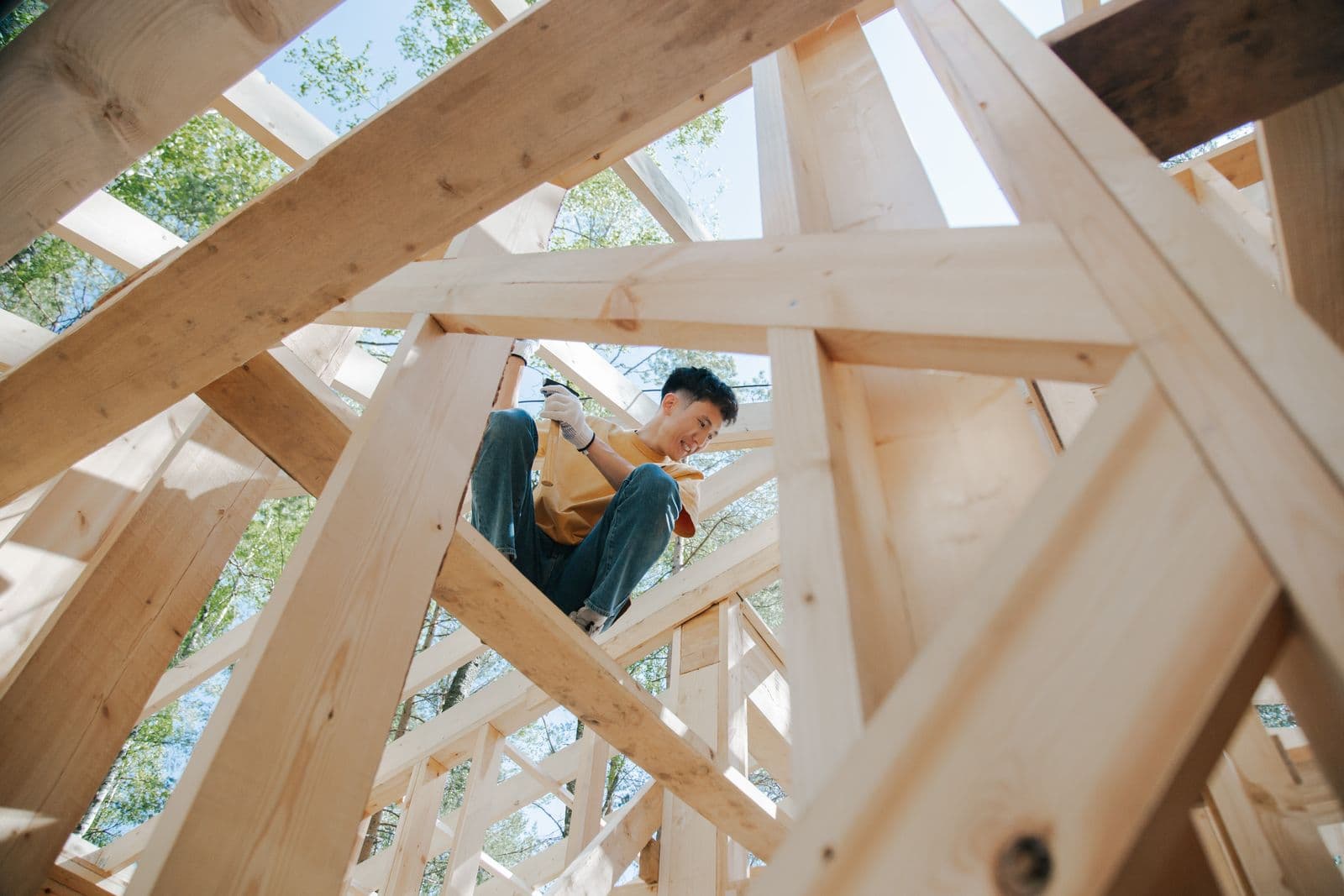 A carpenter working on the timber frame of a house under construction.